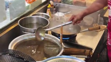 Usta bir aşçı dışarıda Tayland mutfağını tutkuyla pişiriyor.. 