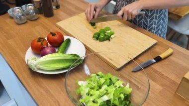 Taze sebzelerden ve çeşitli malzemelerden oluşan lezzetli bir salata pişiren bir şef. 