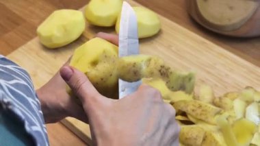 Bir kadın güzel tasarlanmış modern mutfakta ustalıkla lezzetli bir patates hazırlıyor.
