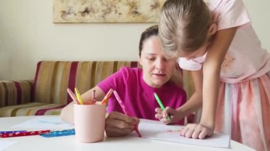 Bir anne ve kızı evde birlikte boyama faaliyetlerinde bulunuyorlar.