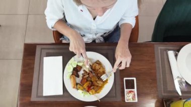 Bir kadın, modern bir kafe ortamında hoş bir yemeğin tadını çıkarıyor.