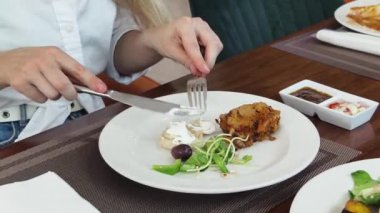 Bir kadın, modern bir kafe ortamında hoş bir yemeğin tadını çıkarıyor.