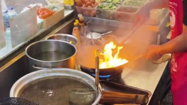 Usta bir aşçı dışarıda Tayland mutfağını tutkuyla pişiriyor.. 