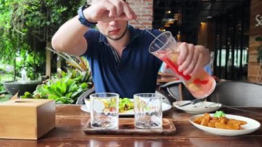 Bir adam modern bir kafe ortamında keyifli bir yemek ve içecekten zevk alıyor.