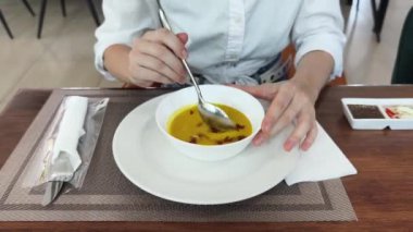 Bir kadın, modern bir kafe ortamında hoş bir yemeğin tadını çıkarıyor.