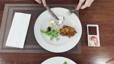 Bir kadın, modern bir kafe ortamında hoş bir yemeğin tadını çıkarıyor.