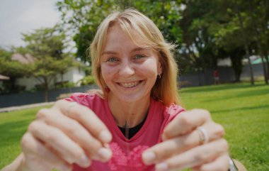 Parkta renkli bilezikler takan genç bir kadın..