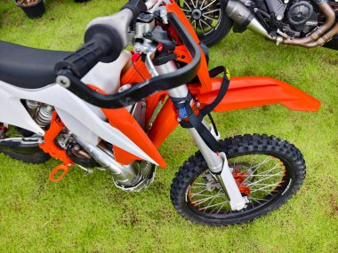 Bir arazi motosikletinin gidonuna odaklanan ayrıntılı bir yakın çekim görünümü.