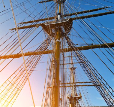 Eski bir geminin direkleri boyunca uzanan uzun ipler.