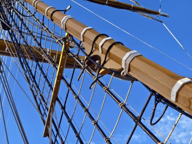 Eski bir geminin direkleri boyunca uzanan uzun ipler.