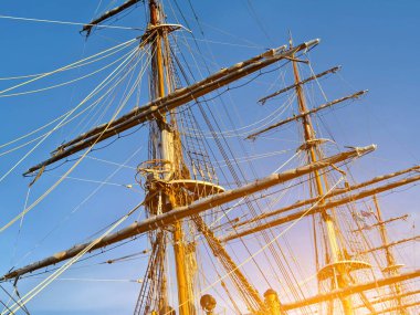 Eski bir geminin direkleri boyunca uzanan uzun ipler.