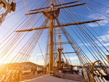 Eski bir geminin direkleri boyunca uzanan uzun ipler.