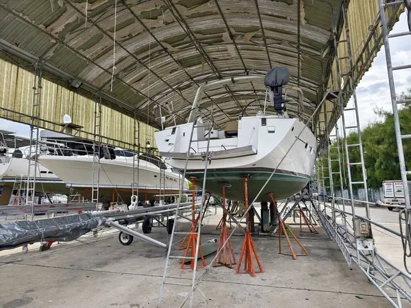 Bir tekne, temel bakım, hazırlık ve aletler için kapaklı bir yapının altında dikkatlice kaldırılır.