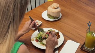 Bir kadın, modern bir kafe ortamında hoş bir yemeğin tadını çıkarıyor.