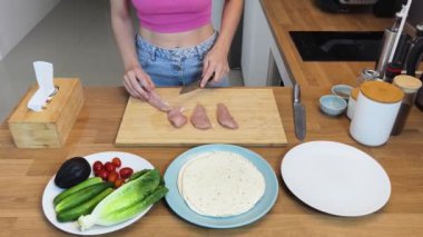 Çağdaş mutfakta Chiken Shawarma 'yı hazırlayan genç bir kadın.