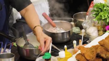 Usta bir aşçı dışarıda Tayland mutfağını tutkuyla pişiriyor.. 