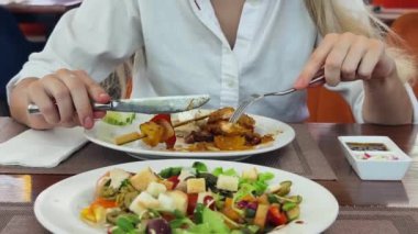 Bir kadın, modern bir kafe ortamında hoş bir yemeğin tadını çıkarıyor.