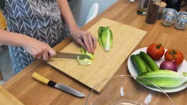 Taze sebzelerden ve çeşitli malzemelerden oluşan lezzetli bir salata pişiren bir şef. 