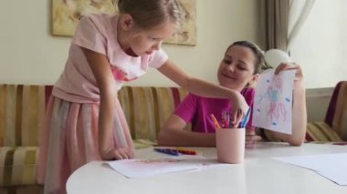 Bir anne ve kızı evde birlikte boyama faaliyetlerinde bulunuyorlar.