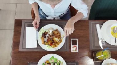 Bir kadın, modern bir kafe ortamında hoş bir yemeğin tadını çıkarıyor.