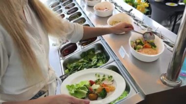 Bir kadın, modern bir kafe ortamında hoş bir yemeğin tadını çıkarıyor.
