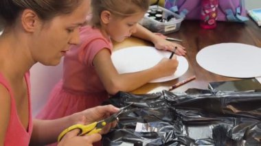 Bir anne ve küçük kızı, yaratıcılığı teşvik eden renkli bir resim faaliyetinde bulunuyorlar.