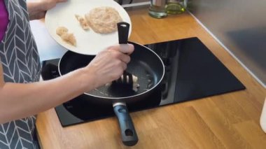 Modern mutfakta ızgara tavuk köftesi pişiren yetenekli bir şef.