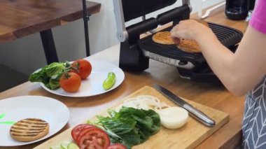 Modern mutfakta ızgara tavuk köftesi pişiren yetenekli bir şef.