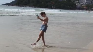 Genç bir kadın kumsalda güzel bir günün tadını çıkarıyor. 