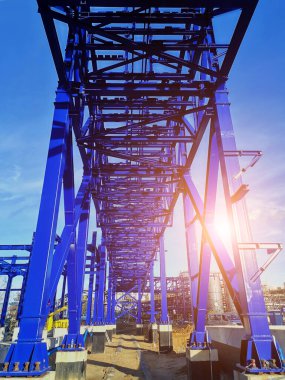 İnşaat alanında mavi gökyüzü zeminine karşı çelik çerçeve yapısı yapım aşamasında.