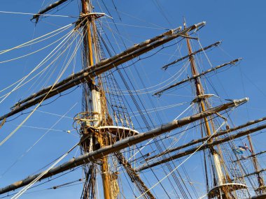 Eski bir geminin direkleri boyunca uzanan uzun ipler.