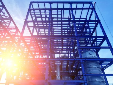 İnşaat alanında mavi gökyüzü zeminine karşı çelik çerçeve yapısı yapım aşamasında.