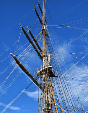 Eski bir geminin direkleri boyunca uzanan uzun ipler.