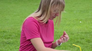 Parkta renkli bilezikler takan genç bir kadın..