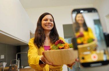 Genç kadın atölyeden canlı yayında vejetaryen yemekleri nasıl hazırlayacağını anlatıyor..