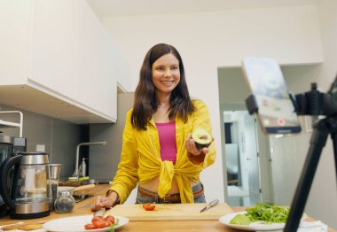 Genç kadın atölyeden canlı yayında vejetaryen yemekleri nasıl hazırlayacağını anlatıyor..