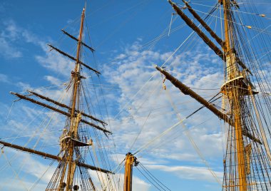 Eski bir geminin direkleri boyunca uzanan uzun ipler.