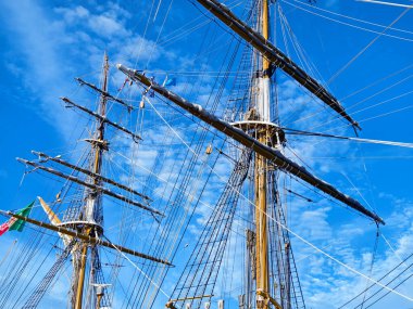 Eski bir geminin direkleri boyunca uzanan uzun ipler.