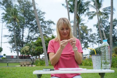 Parkta renkli bilezikler takan genç bir kadın..