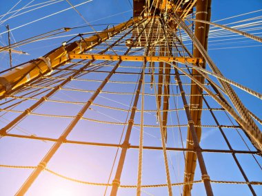 Eski bir geminin direkleri boyunca uzanan uzun ipler.