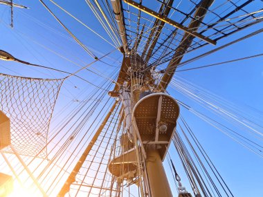 Eski bir geminin direkleri boyunca uzanan uzun ipler.