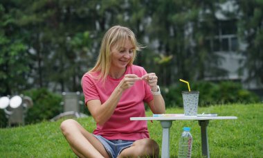 Parkta renkli bilezikler takan genç bir kadın..