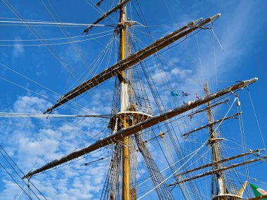 Eski bir geminin direkleri boyunca uzanan uzun ipler.