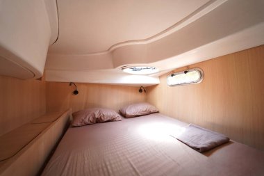 Yolculuk teknesinde rahat bir yatak ve üzerinde doğal ışık olan bir pencere..