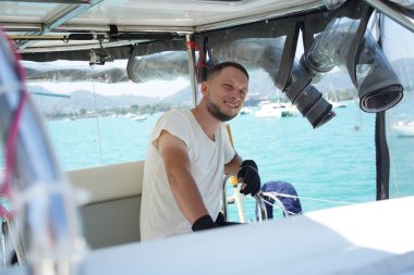 Siyah eldivenli genç erkek kaptan, dümen dümeni..