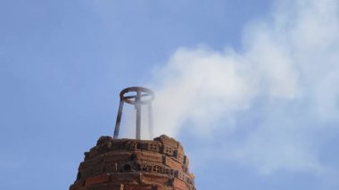 Eski Tayland tapınağındaki havai fişek fırınından çıkan duman kötü ruhları defetmek için dalgalanır..