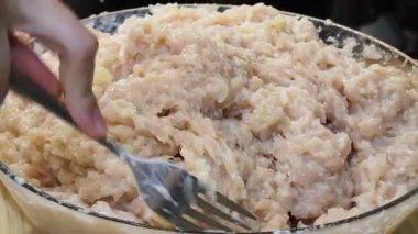 Bir kadın et ve pirzola karıştırarak yemek yapma becerisini sergiliyor..