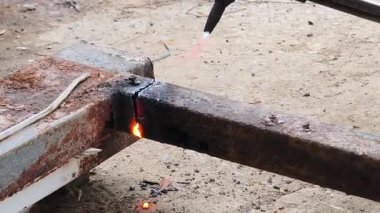 Bir metal işçisi kaynak ve kesim becerileri sergiliyor.