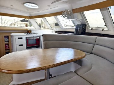 İçinde şık kıvrımlı bir kanepe ve yelkenli teknede bir masa bulunan rahat bir oturma odası ve mutfak..