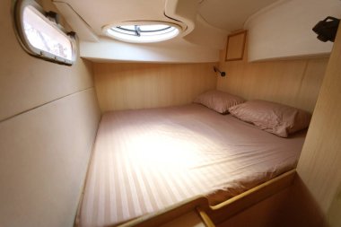 Yolculuk teknesinde rahat bir yatak ve üzerinde doğal ışık olan bir pencere..